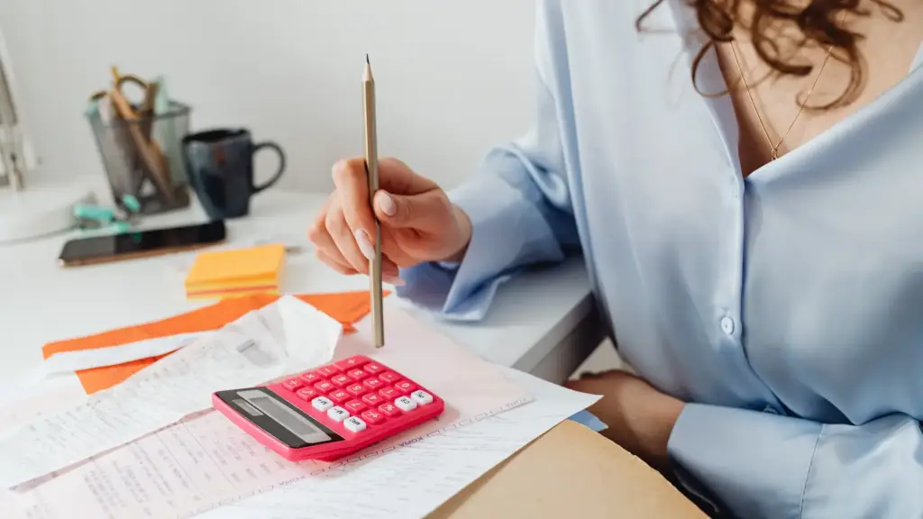 A woman calculating taxes using a calculator.
