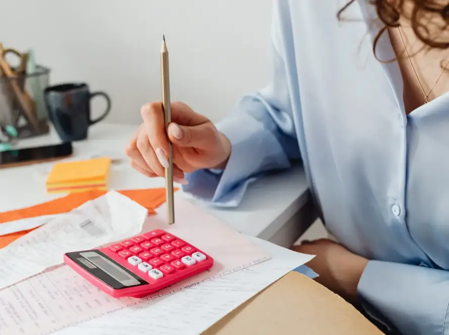 A woman calculating taxes using a calculator.